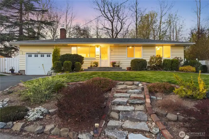 Twilight curb appeal with landscaped yard