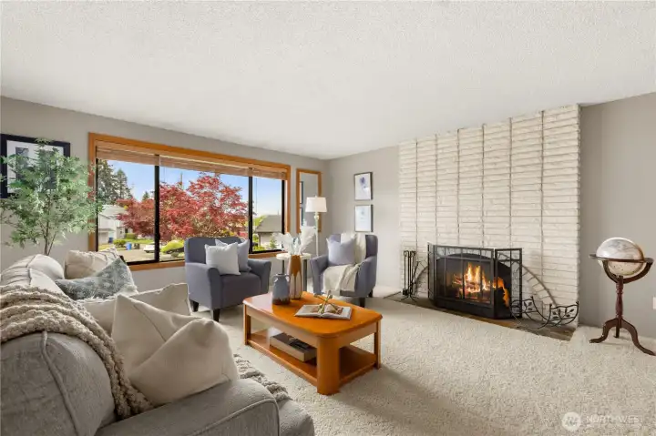The upper-level living room centers around oversized windows and a stunning fireplace.