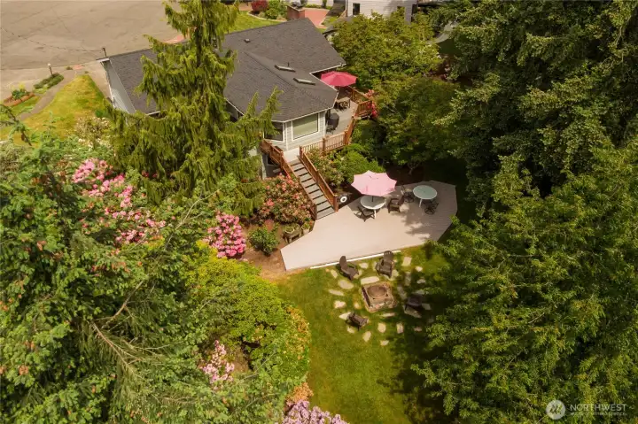 Upper and lower decks, a fire pit, verdant grounds, and an array of blooms make this a beautiful space to relax and entertain.