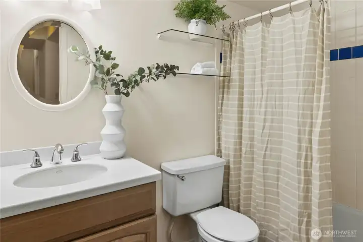 Full bath on lower level with bathtub and tiled shower surround.