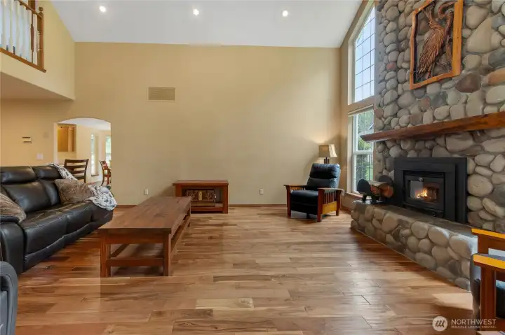 Living room features a stunning river rock fireplace with wood insert.  Floor to ceiling windows.
