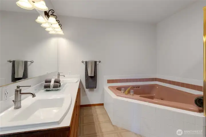 Primary bath with dual vanities and jetted tub, walk-in shower and walk-in closet