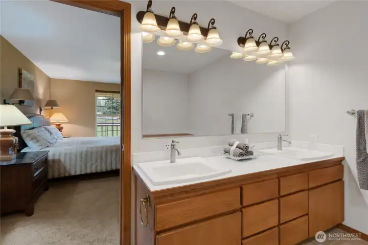 Primary bathroom with dual vanities, jetted tub, separate shower and walk-in closet