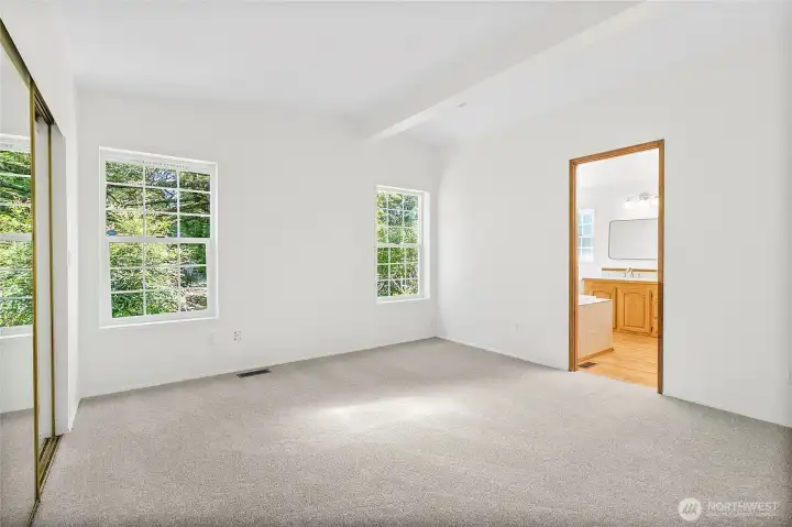 Primary bedroom with door looking into primary bathroom.