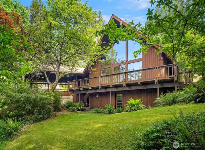 Welcome home to your lush island sanctuary. The A-frame design with dramatic floor to ceiling windows features everchanging northwest light and color.