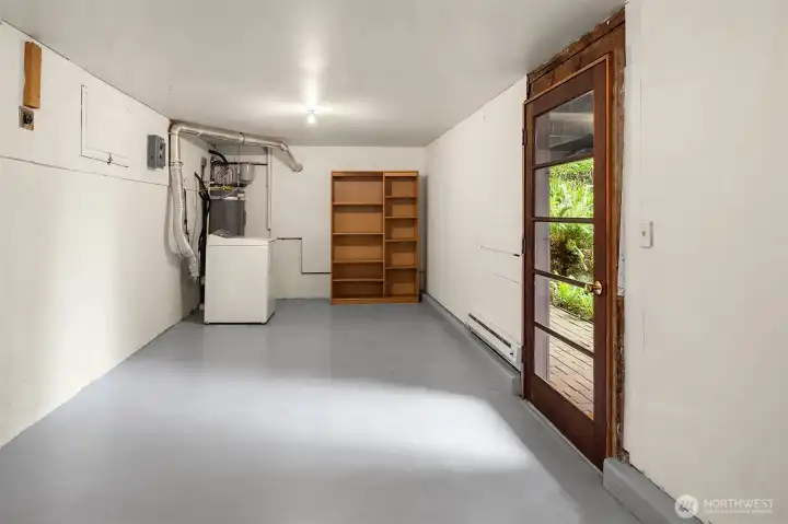 Down steps from the entry patio find the lower level finished and heated laundry/workshop/storage area.