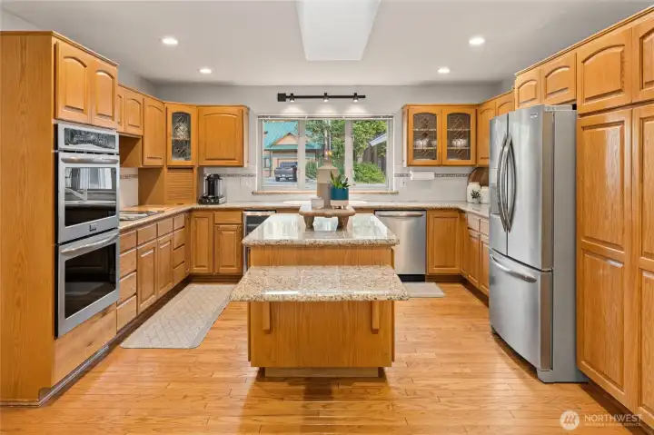 Spacious and inviting, this warm and welcoming kitchen is a delight. Rich oak cabinetry, stainless steel appliances, and a large two-tier island provide abundant workspace and storage, offering plenty of room for everyday meal preparation and effortless entertaining.