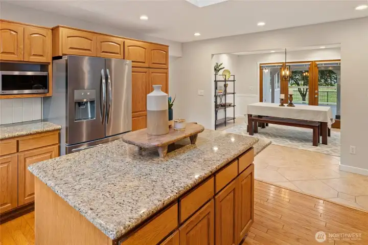 A view from the kitchen into the dining room. Beyond the French doors, a spectacular covered deck extends your living and entertaining space outdoors.