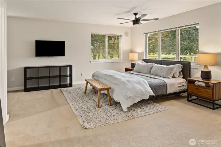 Welcome to the spacious primary suite, featuring abundant natural light and beautiful views through expansive windows.