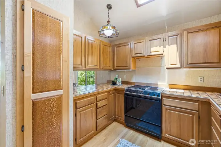 Kitchen with pass through to dining area. Hardwood floors throughout kitchen and dining nook. Kitchen with pass through to dining area. Hardwood floors throughout kitchen and dining nook.