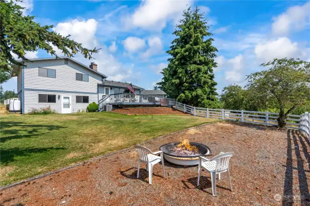 fenced back yard with firepit