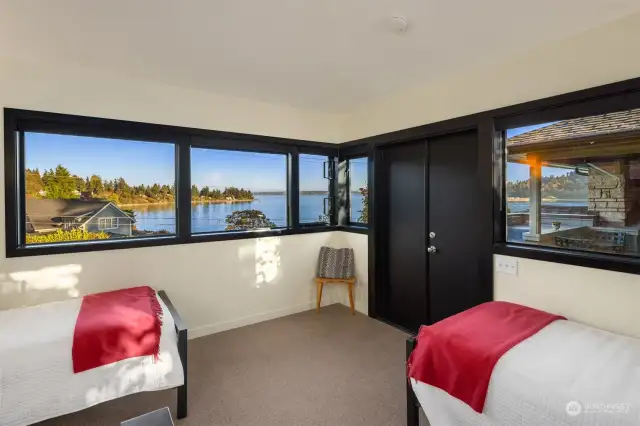 Upstairs bedroom in the guest suite with commanding views of the Sound, Mt Rainier and ferry traffic. Rooftop deck right outside the French doors.