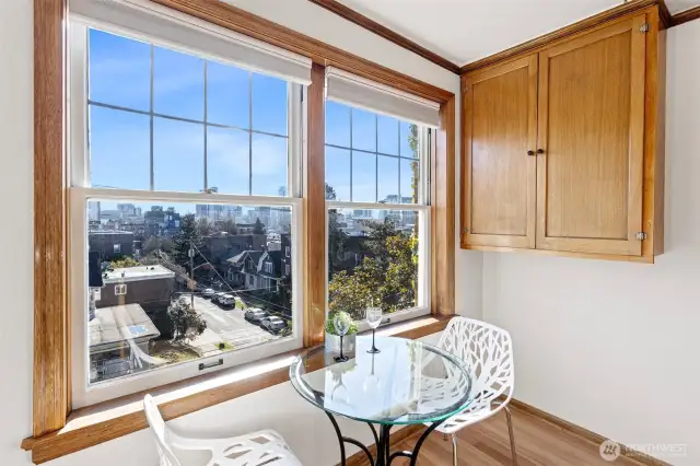 The kitchen’s cozy eating nook is framed by two large south-facing windows, filling the space with natural light and a connection to the outdoors, perfect for savoring your morning coffee in the sun.