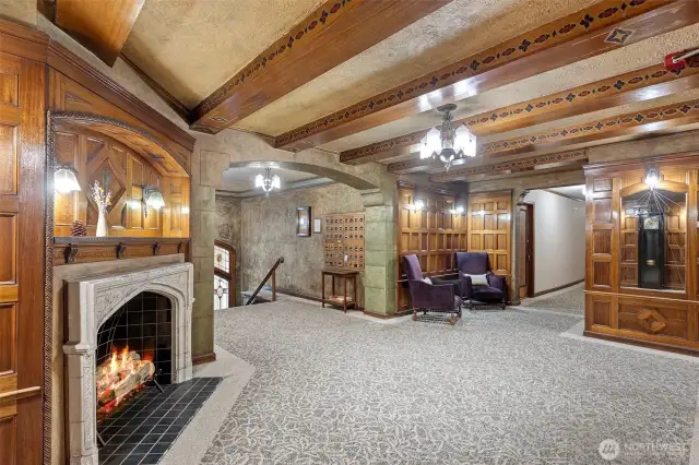 The inviting lobby exudes timeless elegance, with impeccably maintained millwork, stunning stained-glass Art Deco details, a cozy fireplace, and a classic gated elevator that whispers of a bygone era.