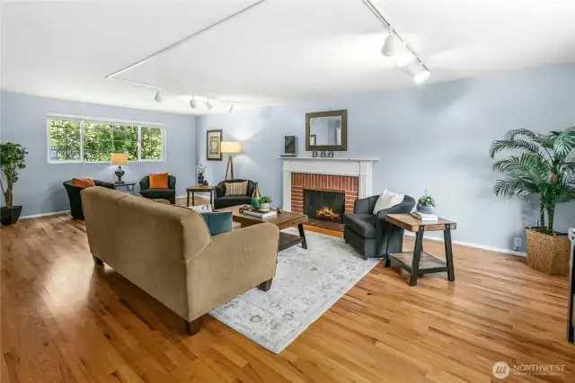 The living room is grand, and lovely. Windows at both ends and the warmth of the wood-burning fireplace set off the space.