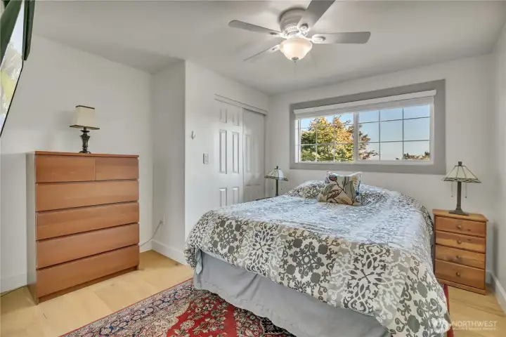 Bright bedroom with engineered hardwood flooring.