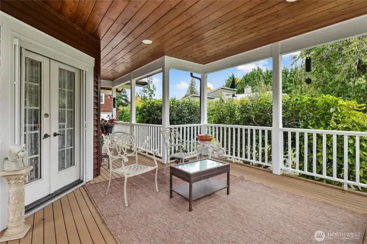 Veranda and large deck looking toward back of house and ADU.  Gorgeous french doors lead from front room to deck.