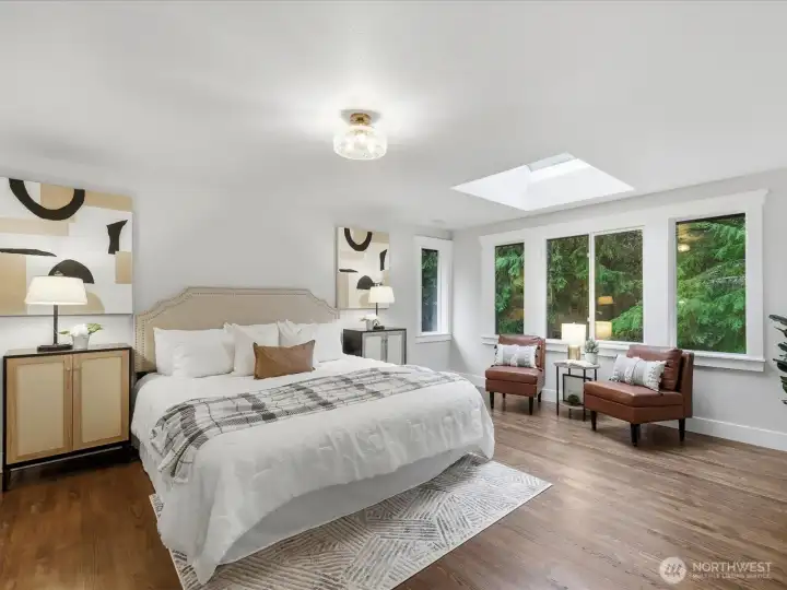 Primary Suite with skylight backing to lush greenbelt.