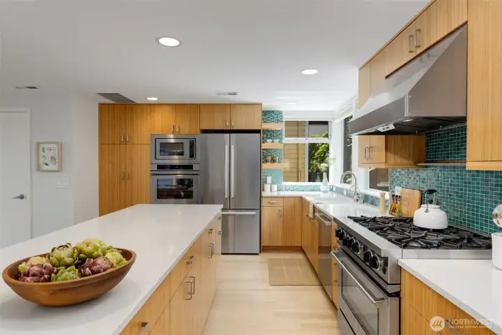 True chefs kitchen with high end gas stove/gas oven, electric oven, built in microwave and built in warming drawer. As well as insta-hot faucet