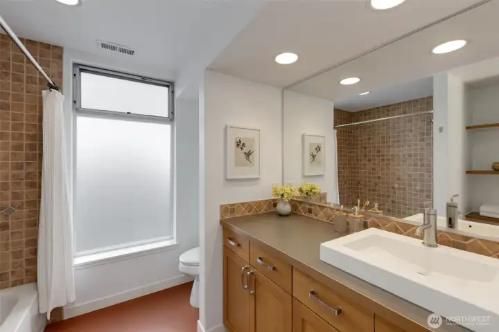 Second floor full bathroom with detailed tile work and marmoleum floors