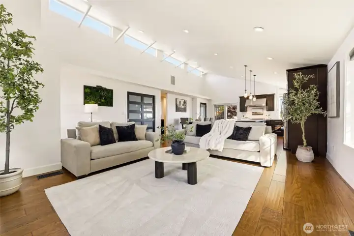 Windows line the vaulted ceilings giving the living room an open, spacious feeling as it leads into the kitchen