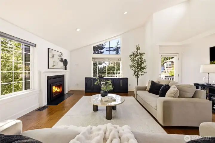 Flooded with natural light, the living room features a large floor to ceiling front window, a cozy gas fireplace, and a front deck that's perfect for sipping coffee in the morning