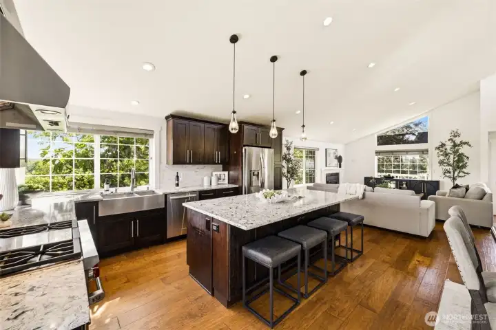 The kitchen features stainless steel appliances, a gas Wolf range, and plenty of space for a large dining table