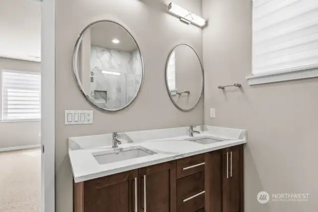 Primary bathroom with double sinks and separate mirrors.