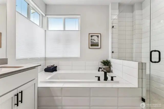 Gorgeous primary bath, deep soaking tub w/gorgeous tile surround and 2 large operable windows.