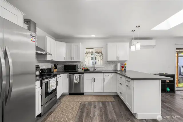 Large kitchen with quartz countertops and stainless steel appliances.