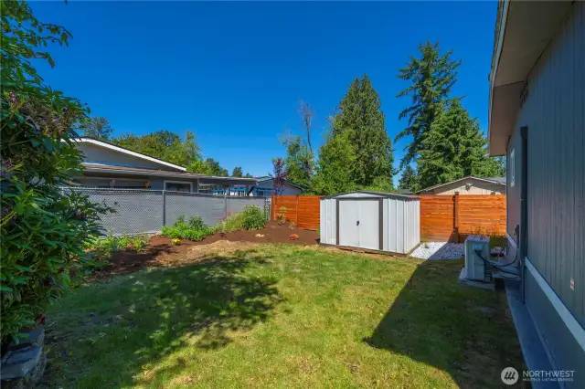 Fully fenced in yard with storage shed.