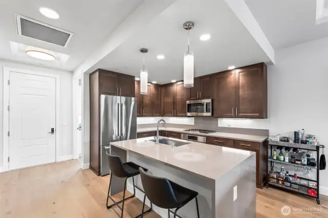 Breakfast bar island with the quartz extending to a waterfall edge. Quite elegant.
