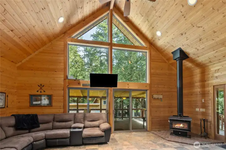 Gorgeous great room with toasty free standing wood stove, floor to ceiling windows.