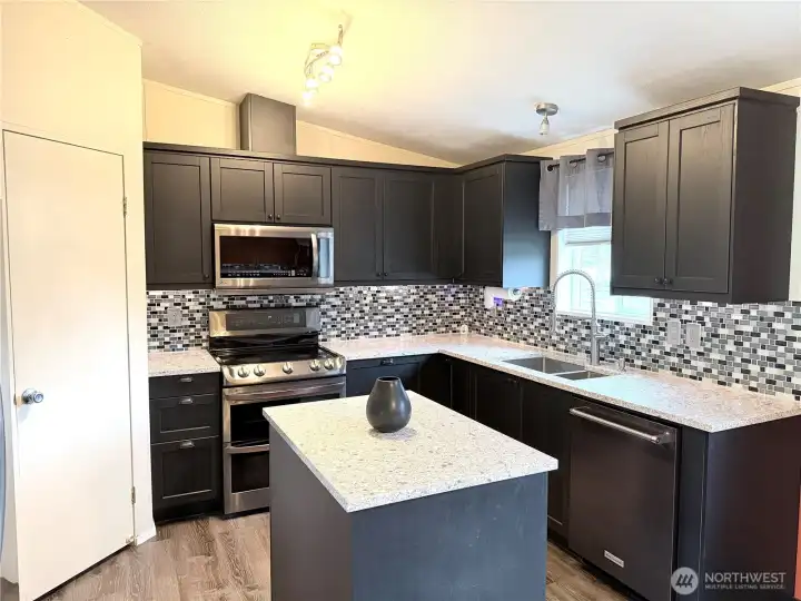 Quartz countertops and tile back splash, this kitchen was thoughtfully updated.