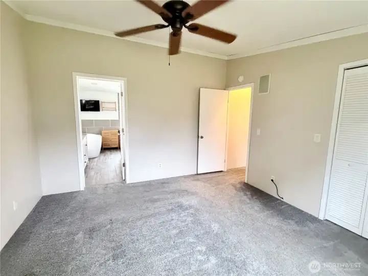 Spacious primary bedroom full of natural light.