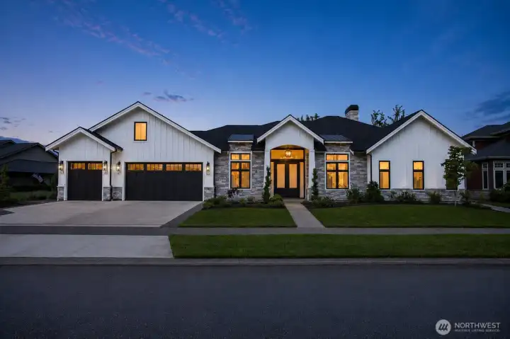 Welcoming front entry with vaulted architectural details, stonework accents, and professionally landscaped grounds.