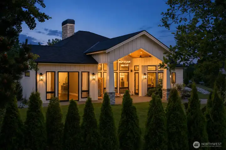 Twilight view showcasing the home's covered outdoor retreat, architectural details, and inviting entertaining spaces.