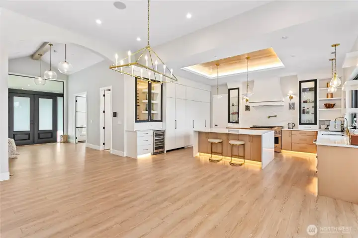 Open-concept kitchen and living space highlighted by custom cabinetry, quartz surfaces, designer lighting, and luxury finishes.