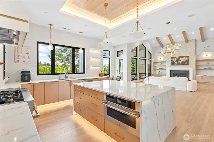 Light-filled great room and chef's kitchen with custom cabinetry, statement lighting, and expansive gathering spaces.