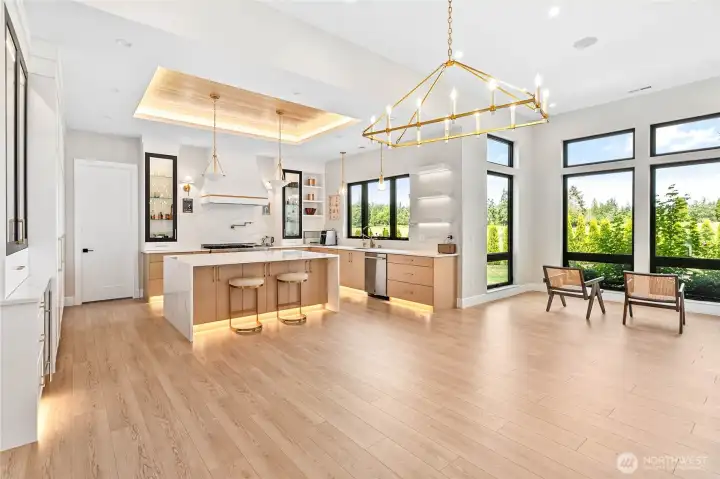 Light-filled great room and chef's kitchen with custom cabinetry, statement lighting, and expansive gathering spaces.