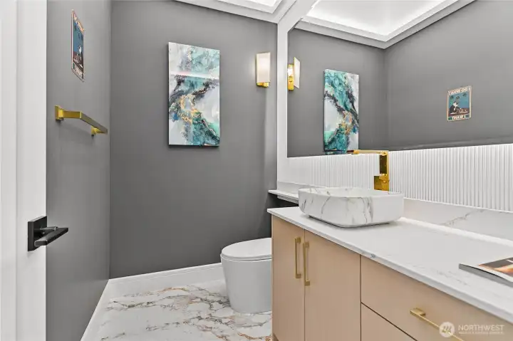 Beautifully appointed half bath with custom cabinetry, quartz surfaces, and modern gold fixtures.