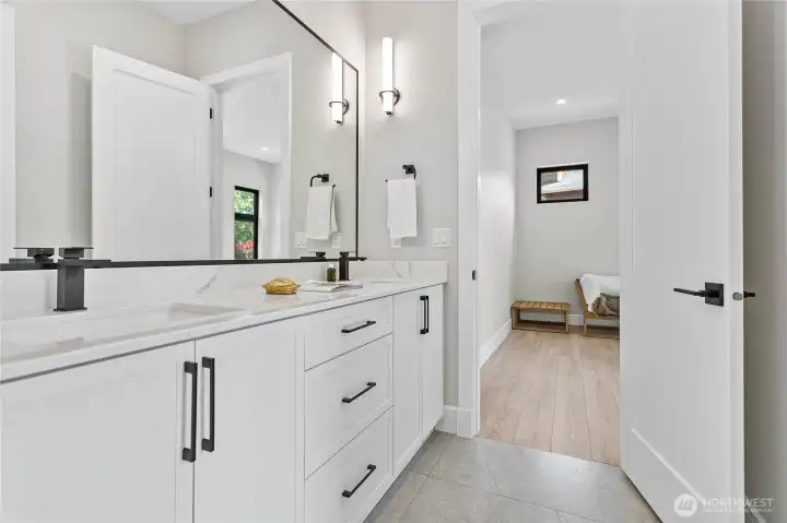 Jack-and-Jill Style Bathroom    Connecting the two secondary bedrooms, this well-designed bathroom offers a large dual vanity, ample storage, contemporary finishes, and an oversized walk-in shower with frameless glass enclosure. A perfect blend of convenience, comfort, and modern design for family or guests.