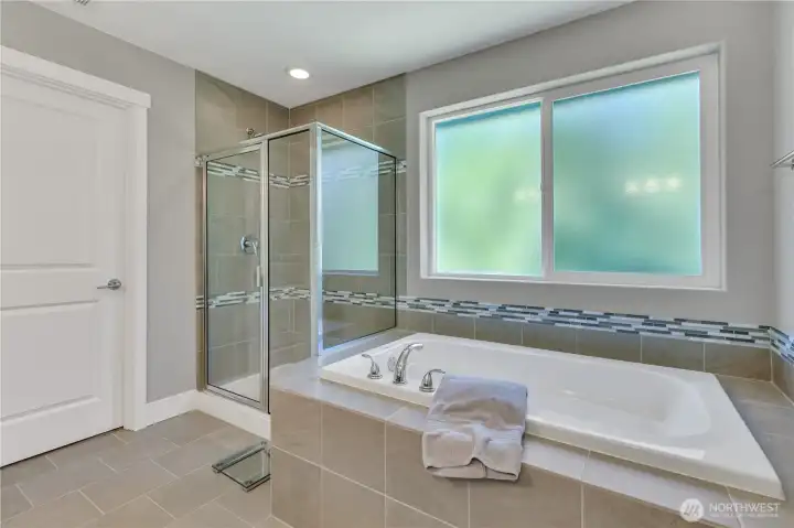 Primary suite soaking tub; bedroom and bath both face the private greenbelt Primary suite soaking tub; bedroom and bath both face the private greenbelt