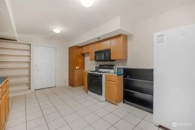 Through the Primary kitchen is a secondary kitchenette with a door that leads to the garage, and another door that leads to the private back deck space.