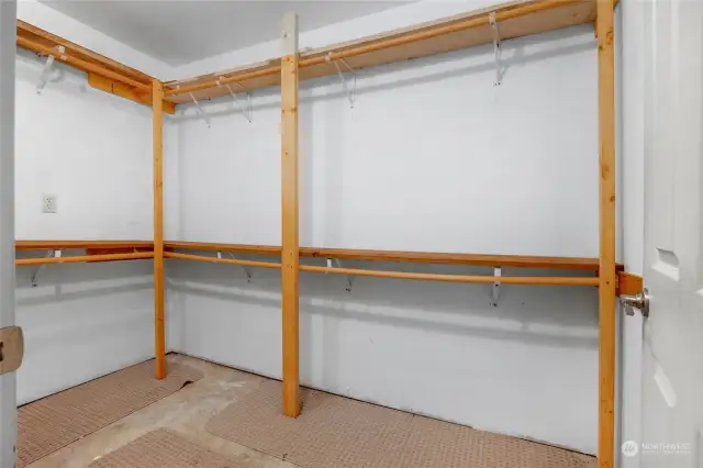 Walk in closet that is L Shaped providing plenty of storage.