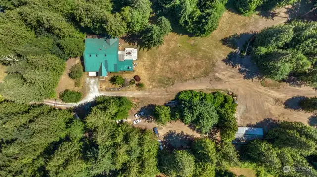 Aerial View showing the home and shop proximity. The property has a lot of already cleared areas that extends much farther back.