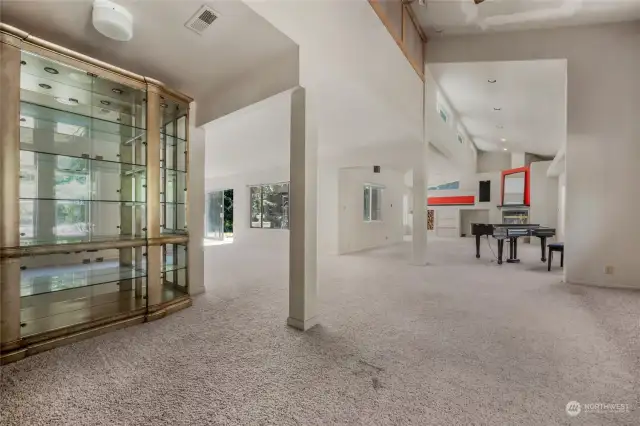 As you enter, you are welcomed into a large foyer, that leads into this oversized living area with high ceilings.