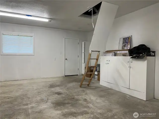 Pull down ladder accesses above garage storage space.