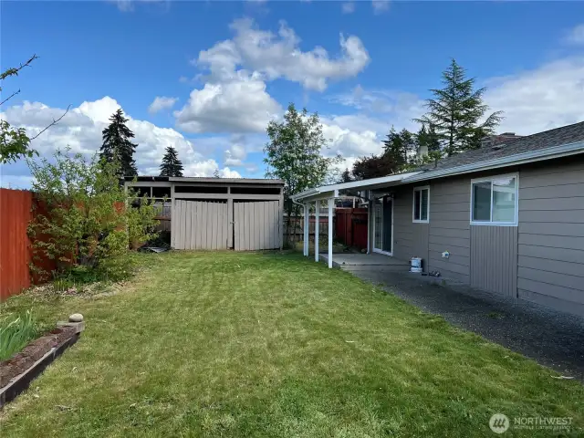 The fenced back yard has a deck and patio.