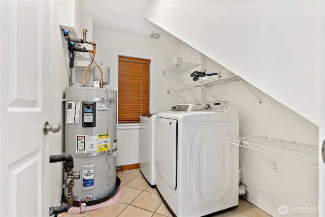 Newly installed water heater (2025) in laundry room with additional storage space